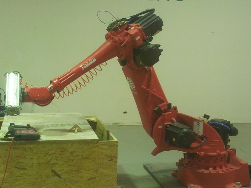 Braç robòtic industrial Comau treballant sobre una peça de fusta a un fablab